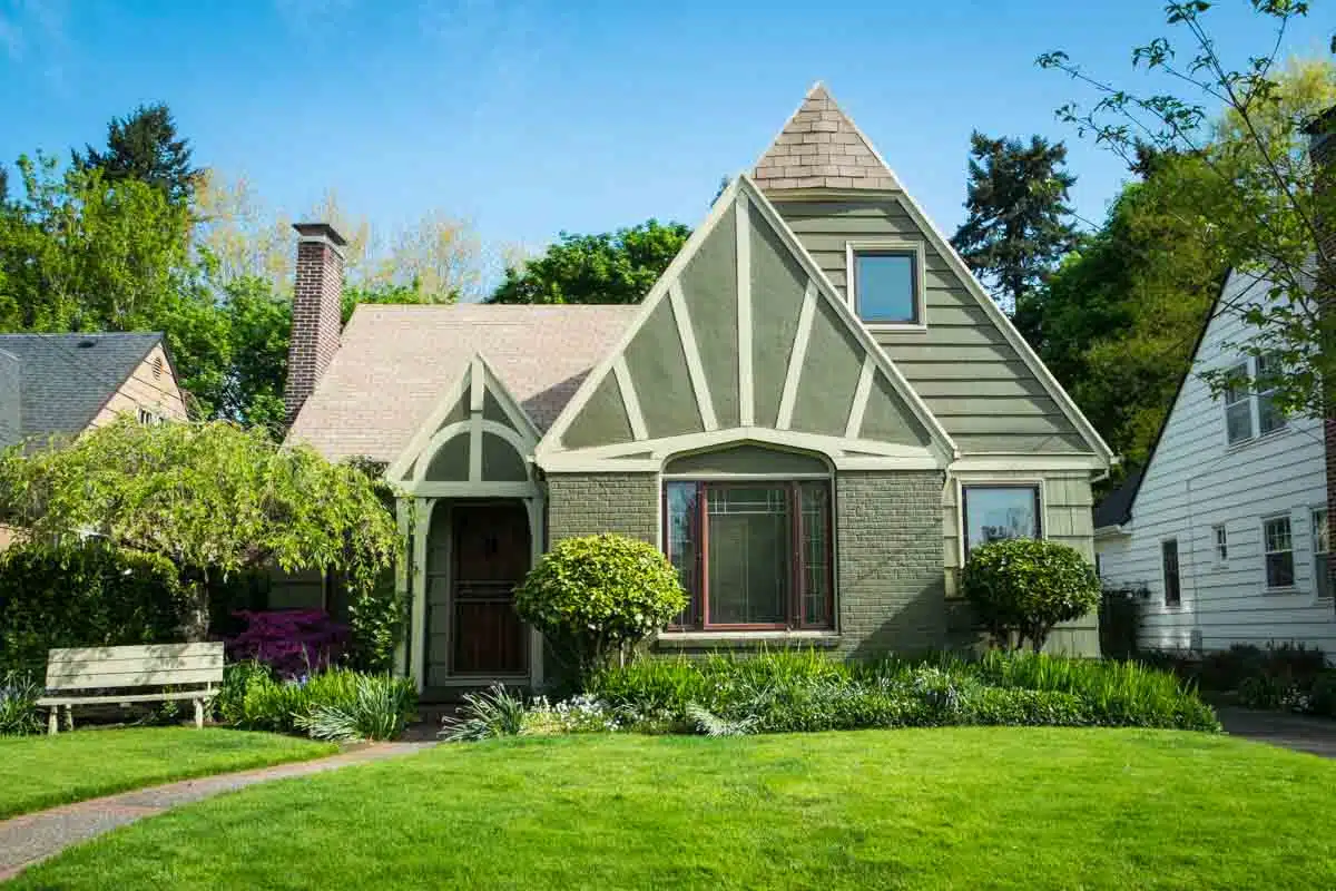 green craftsman house with siding windows and door