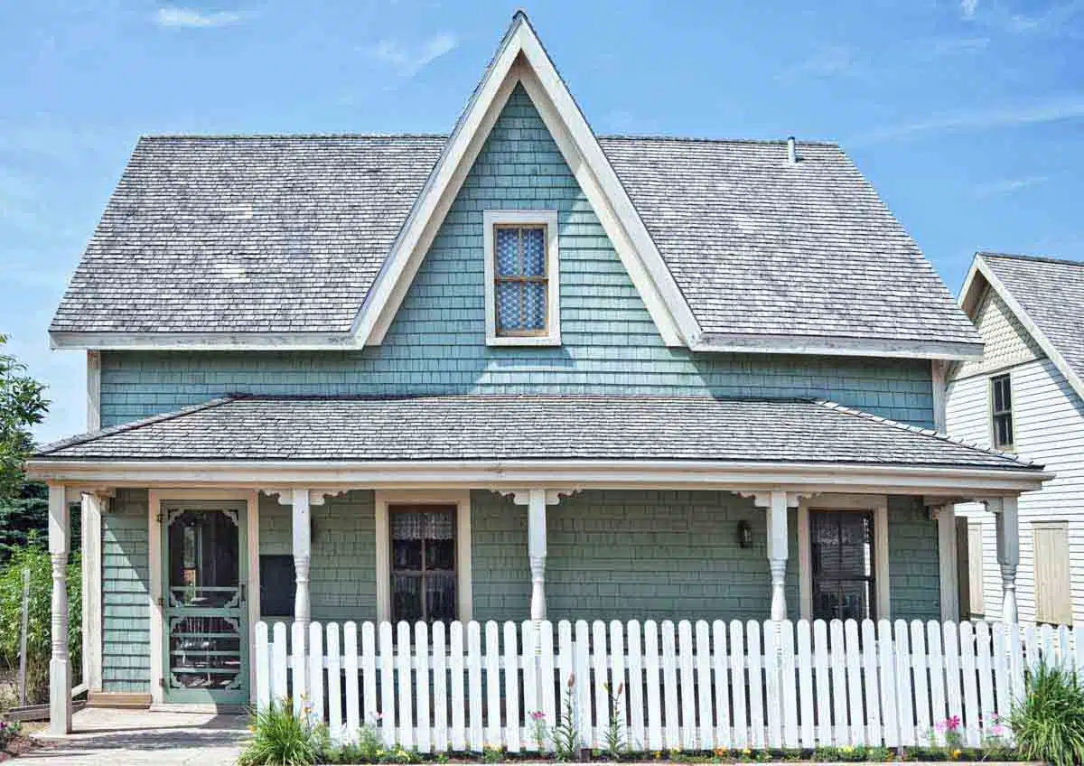light blue house with picket fence