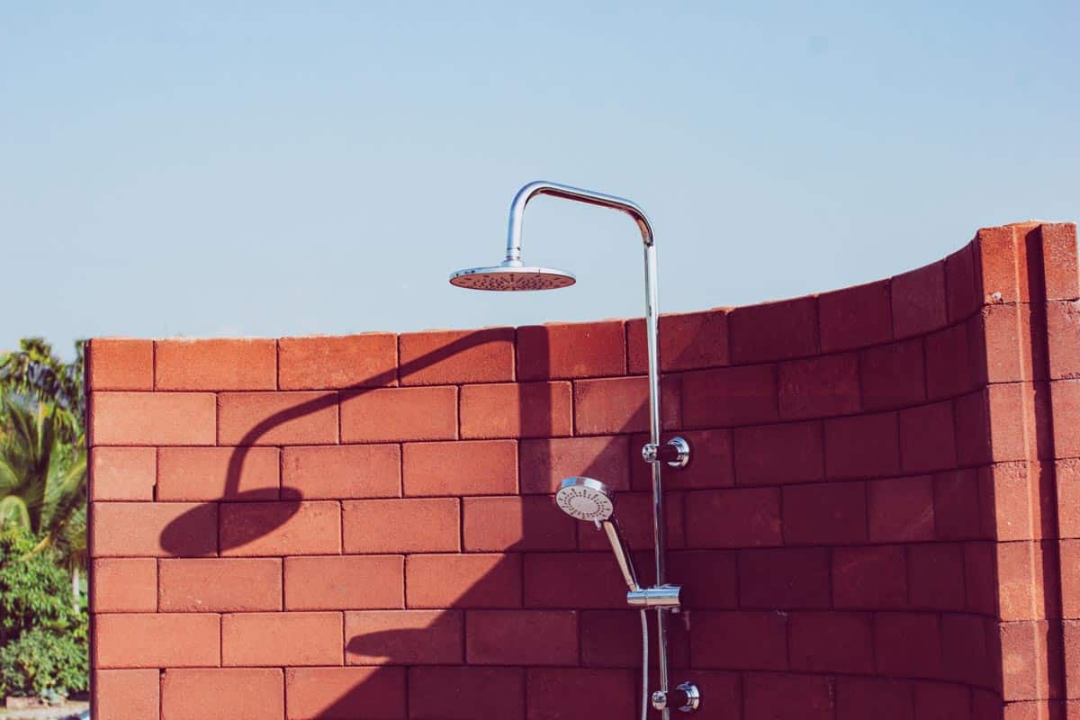 outdoor shower with orange brick curved wall