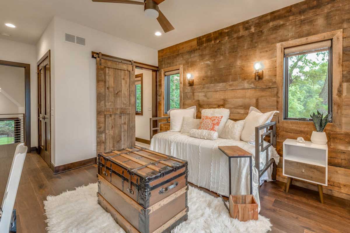 room with rustic pallet wall couch wood floors and ceiling fan
