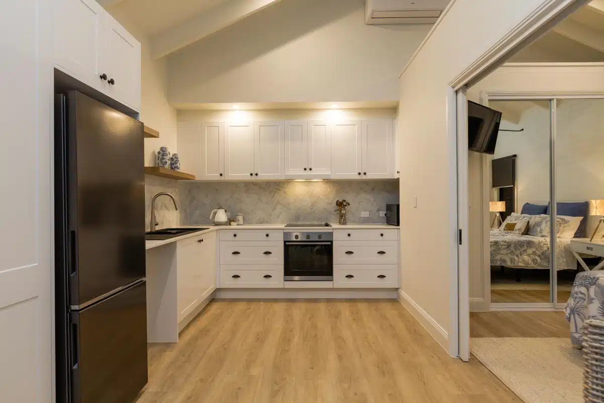 spacious basement kitchen with wood flooring and cabinets