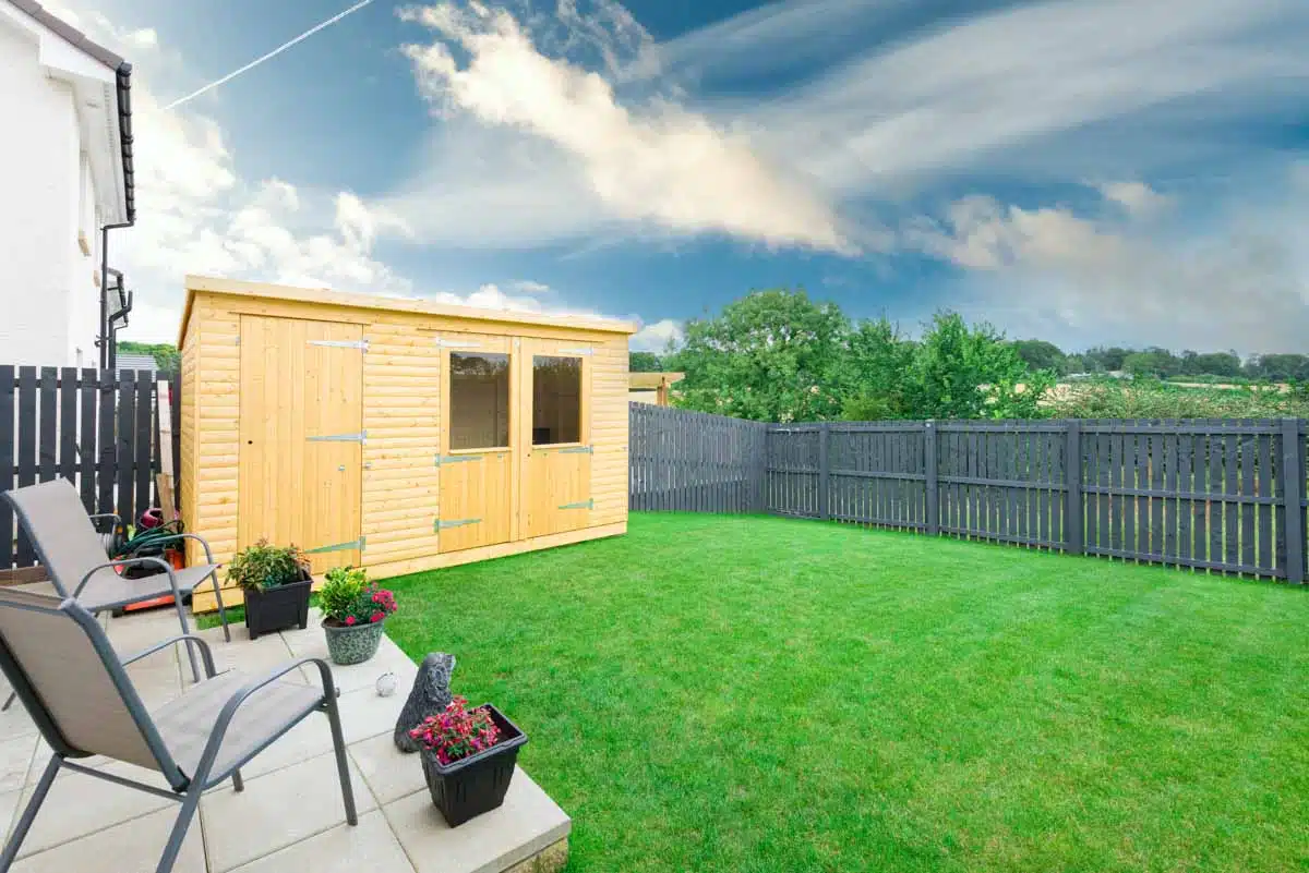 yard with navy blue fence and shed