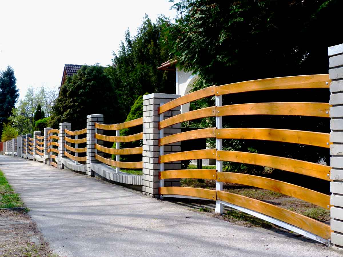 yellow fence with concrete brick pillars
