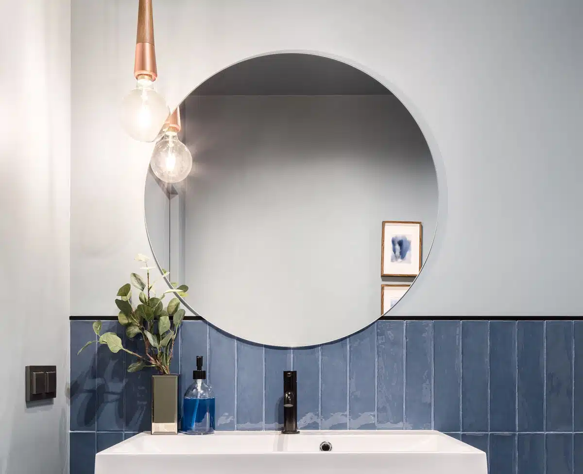 bathroom with tile backsplash and mirror
