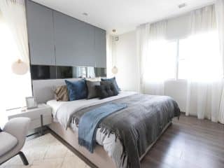 bright bedroom with curtains and accent wall