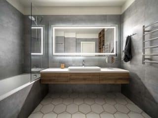 concrete bathroom with floating vanity mirror and tub