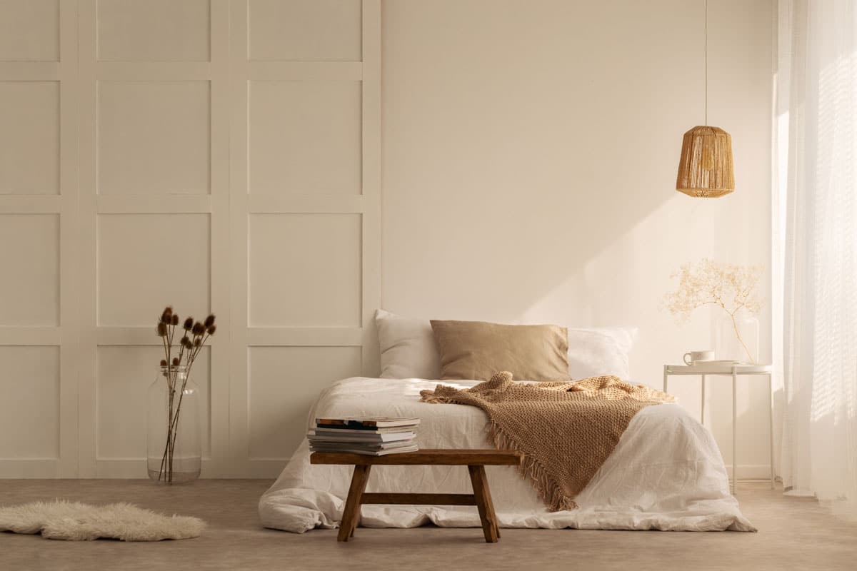 cream bedroom with pendant light and bedding
