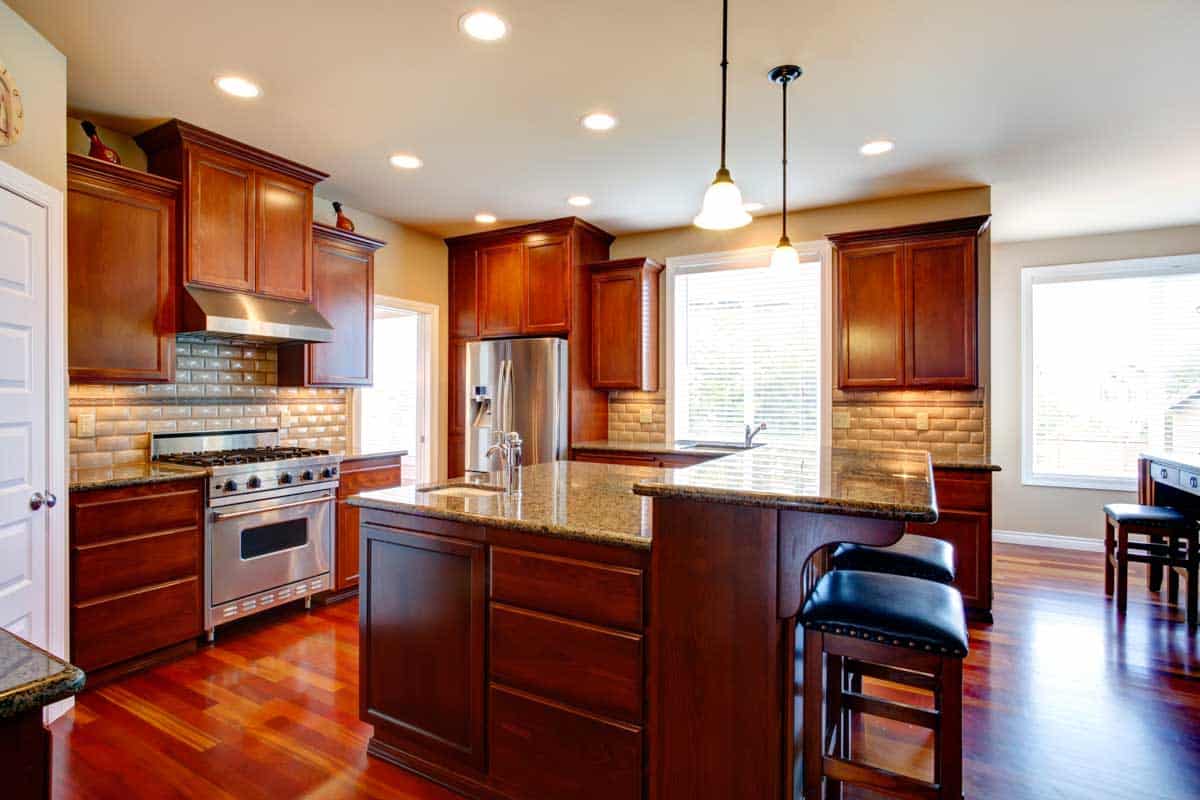 kitchen with dark red floor and pendant lights