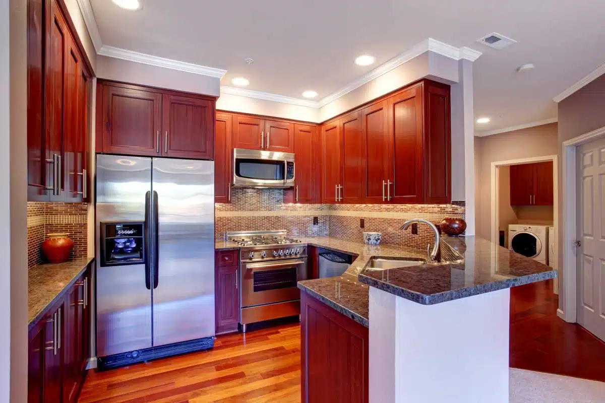 kitchen with light toned cherry floor refrigerator and crown molding