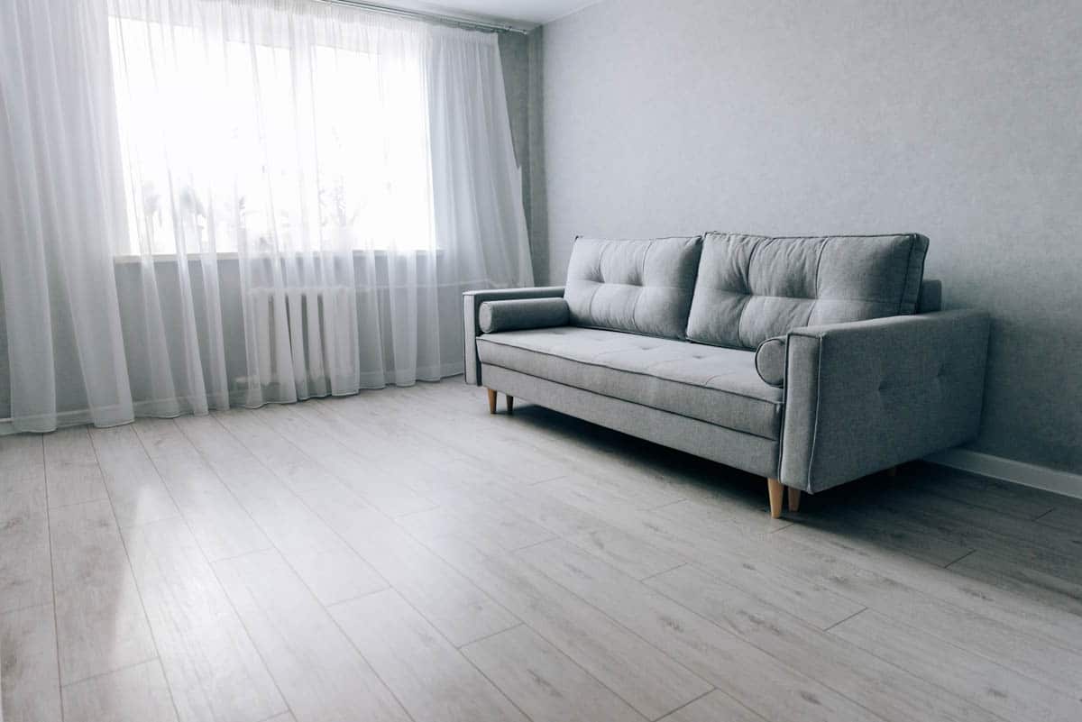 living space with light colored floors couch and curtain