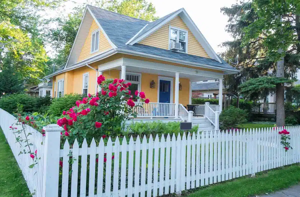 yellow house with front porch and fence