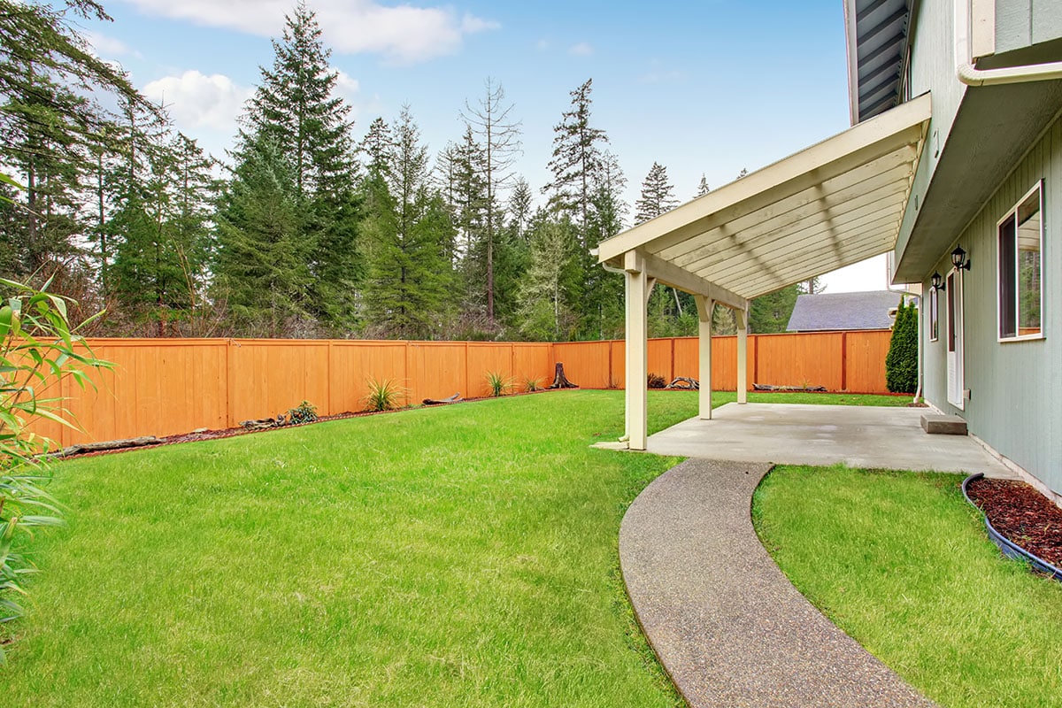 Backyard lawn with wooden fence pergola