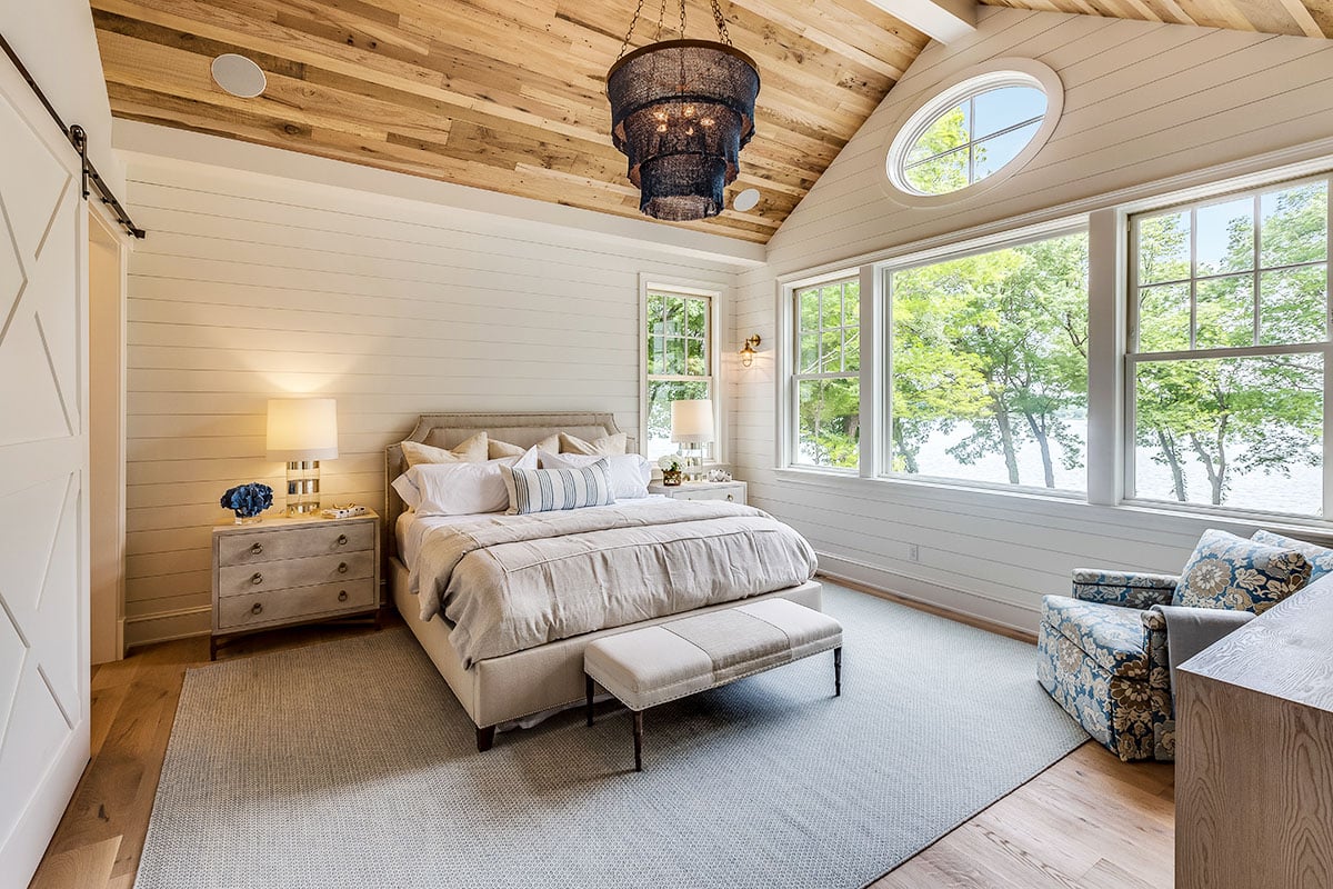 Bedroom with shiplap wall picture window wood plank ceiling