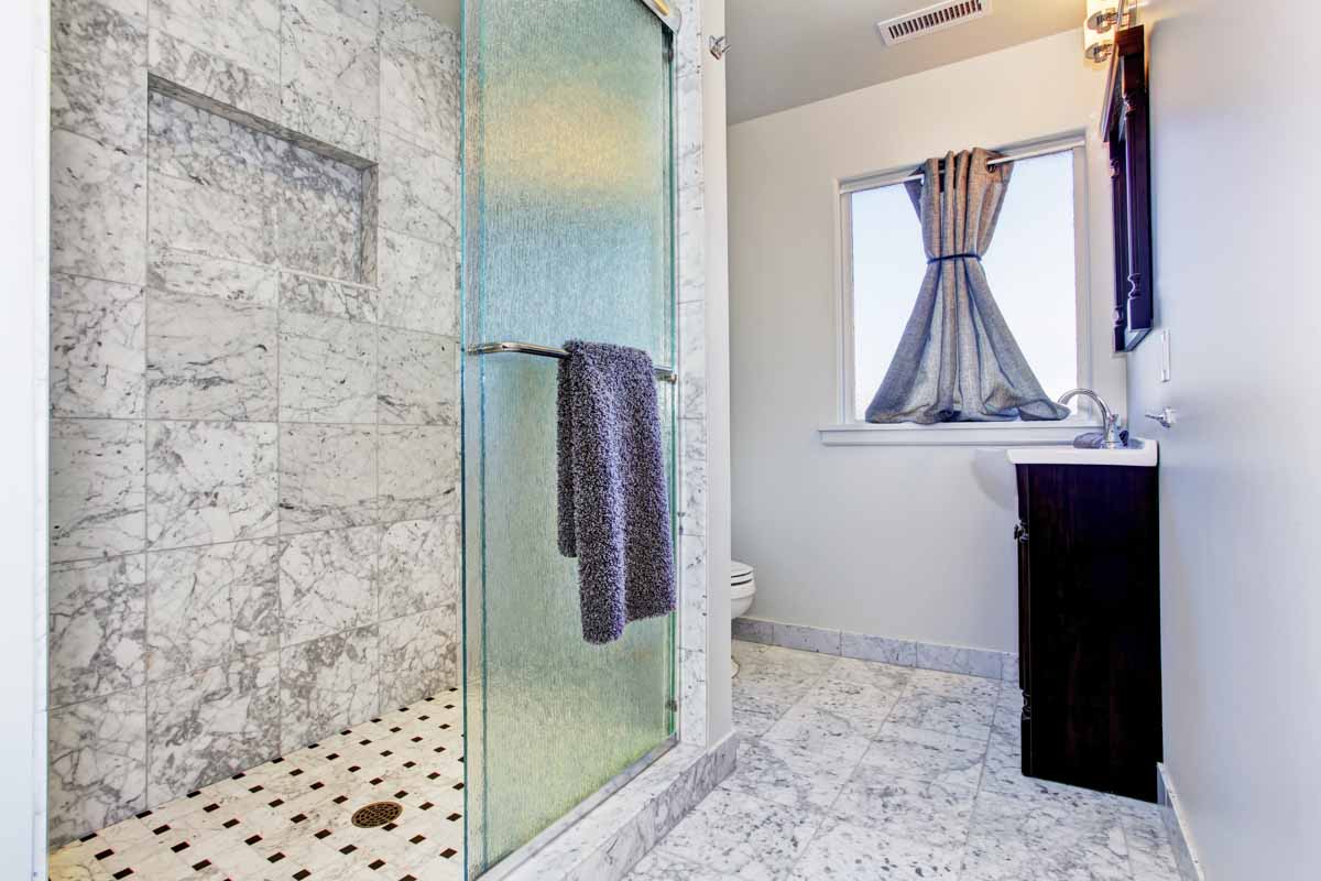 bathroom with glass shower door and window