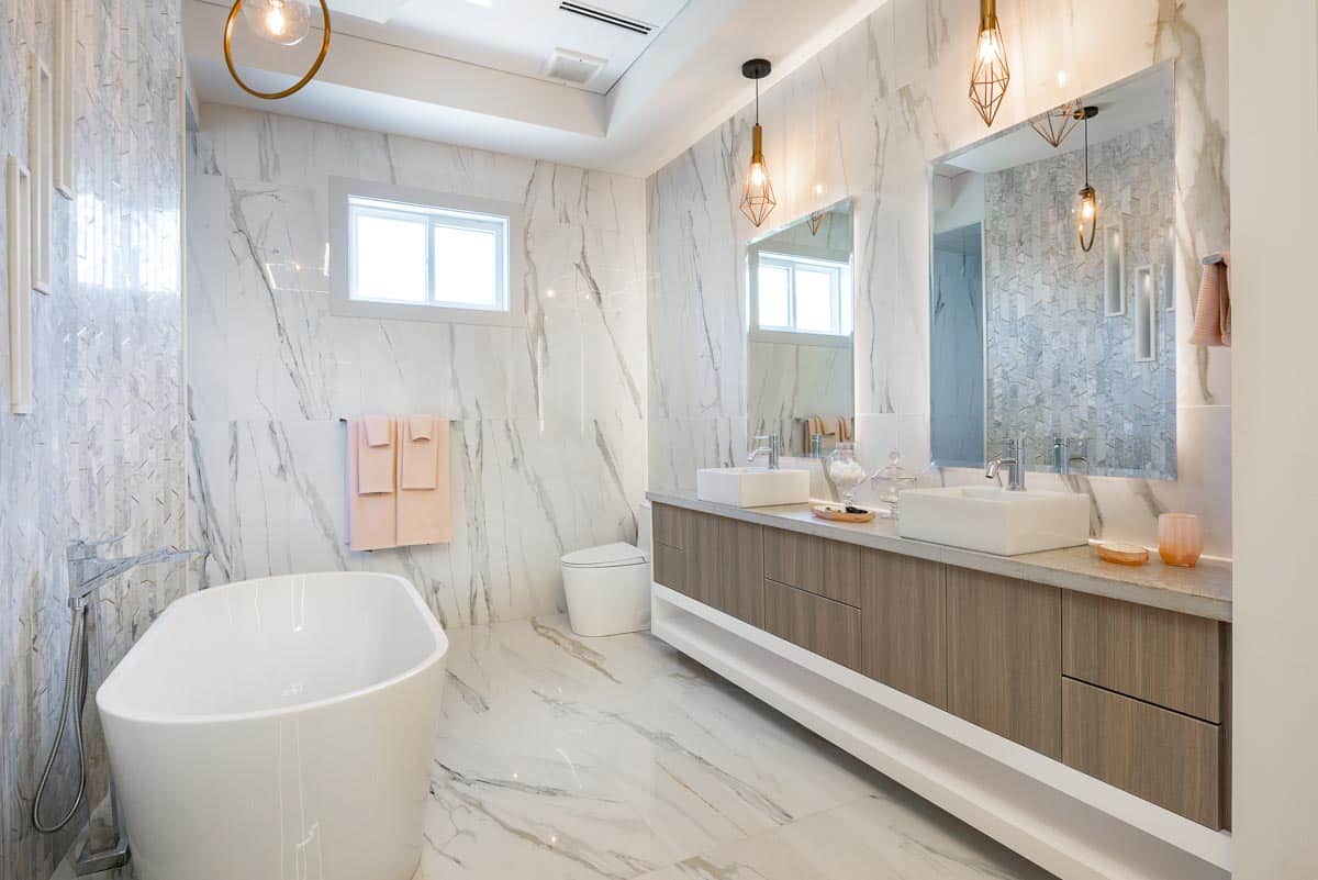 bathroom with marble tiles mirror counter and tub