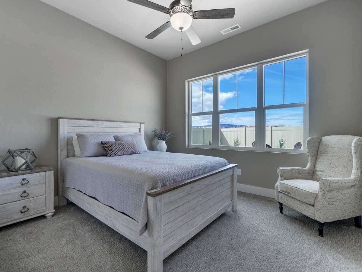 bedroom with ceiling fan and accent chair