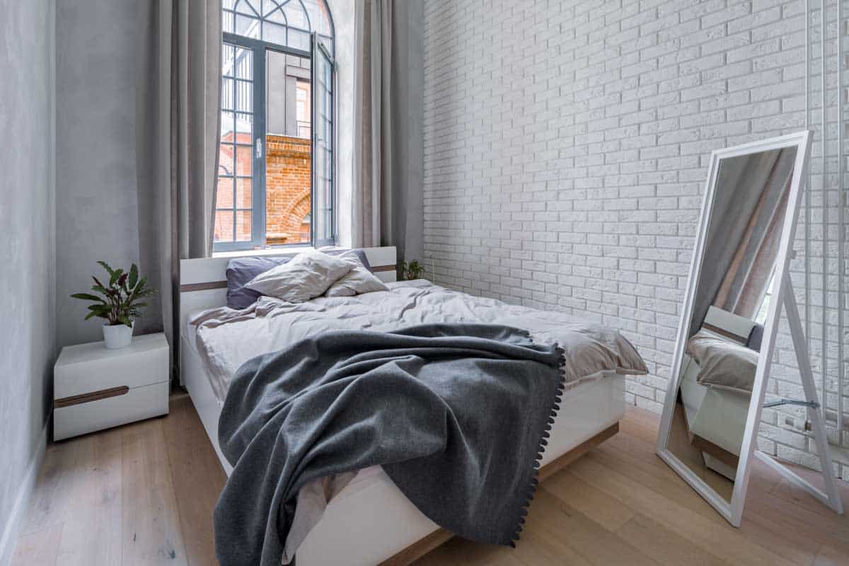 bedroom with mirror nightstands and window