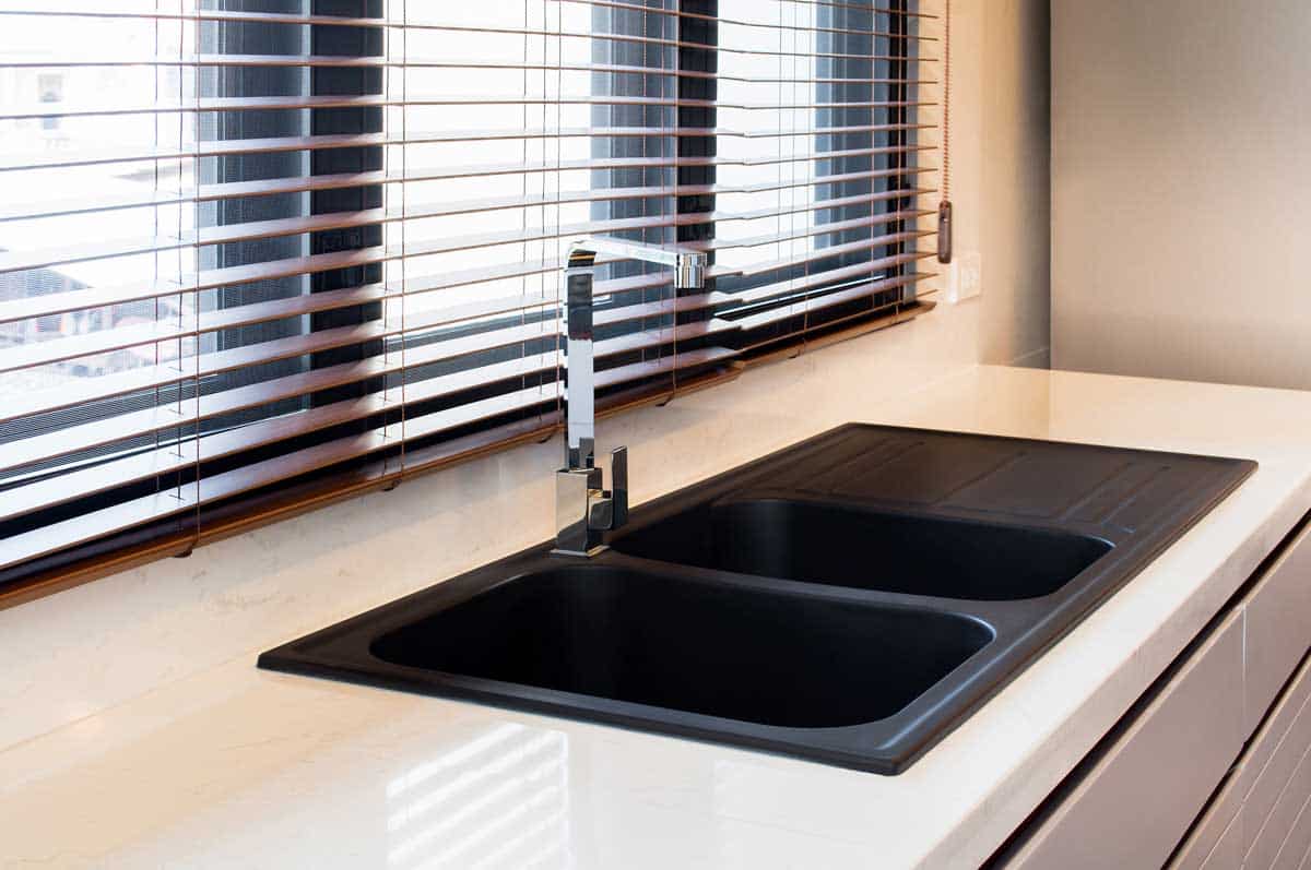 kitchen area with black sink and window blinds