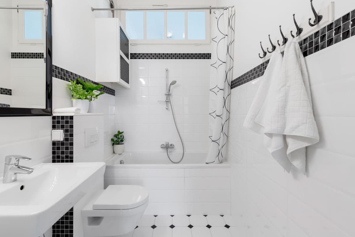 white and black bathroom with shower mirror and sink