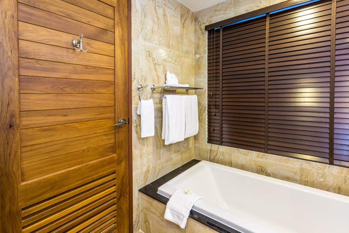 bathroom with wood door and blinds