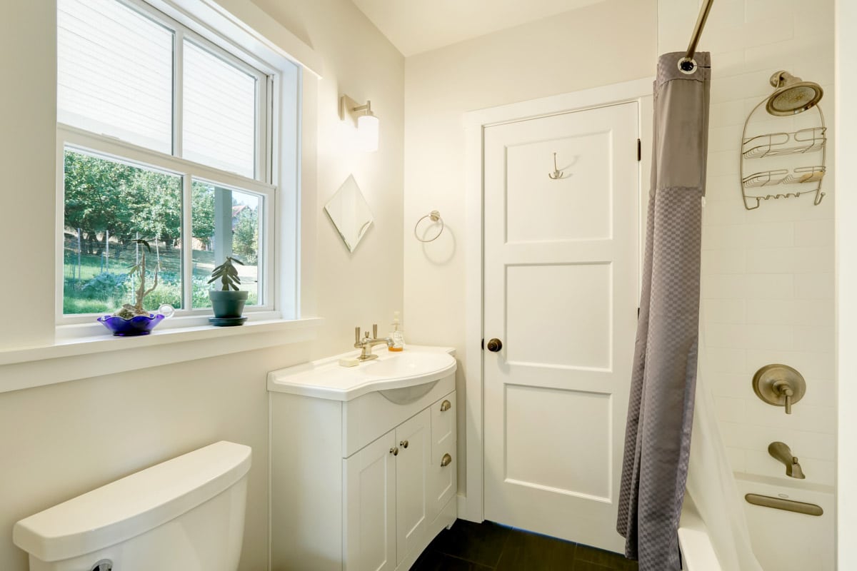 white bathroom with cabinet and window