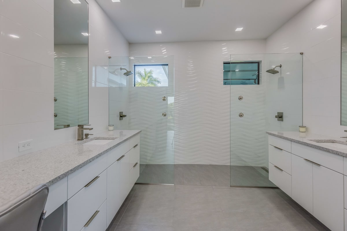 white bathroom with shower area and countertops