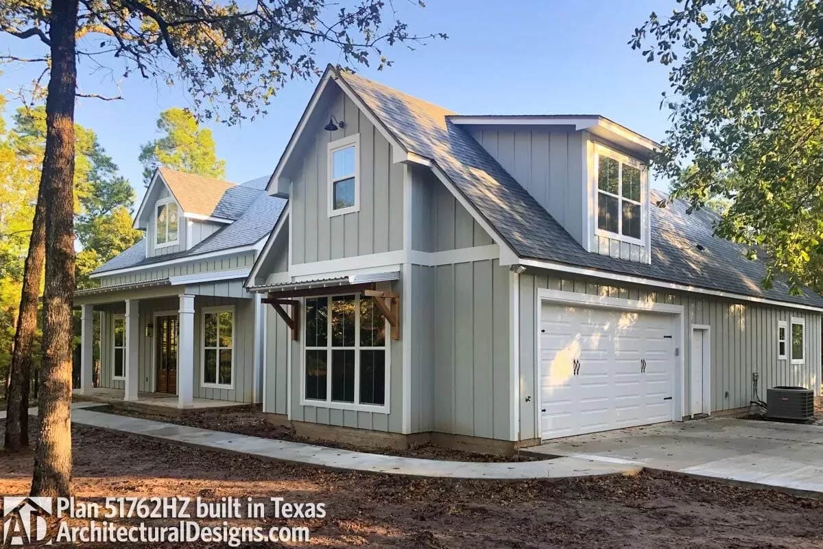 House painted pale green with white beams and window trim