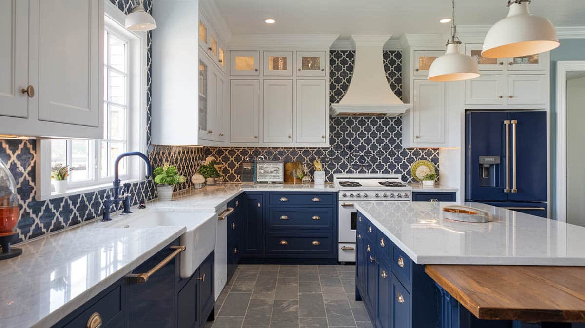 Coastal designed kitchen with navy for lower cabinets and white for upper cabinets with pattern tile on walls