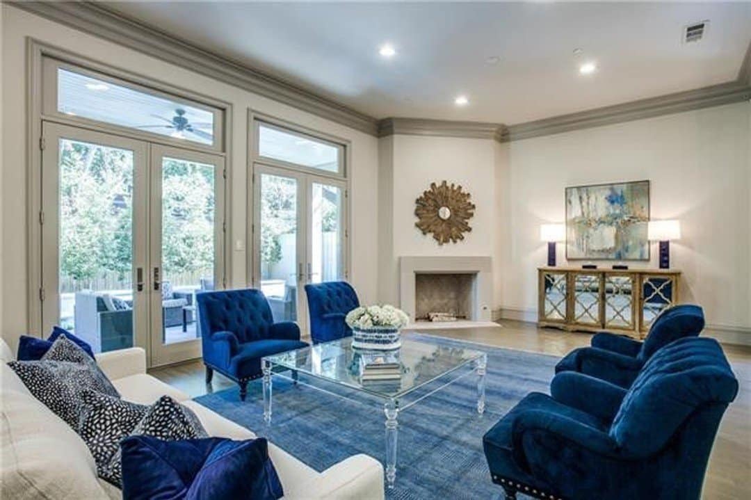 Contemporary living area with blue arm chairs, area rug and throw pillows on cream sofa