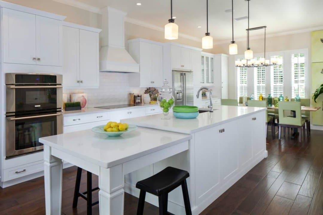 Country designed kitchen with white shaker cupboards and dark plank floors