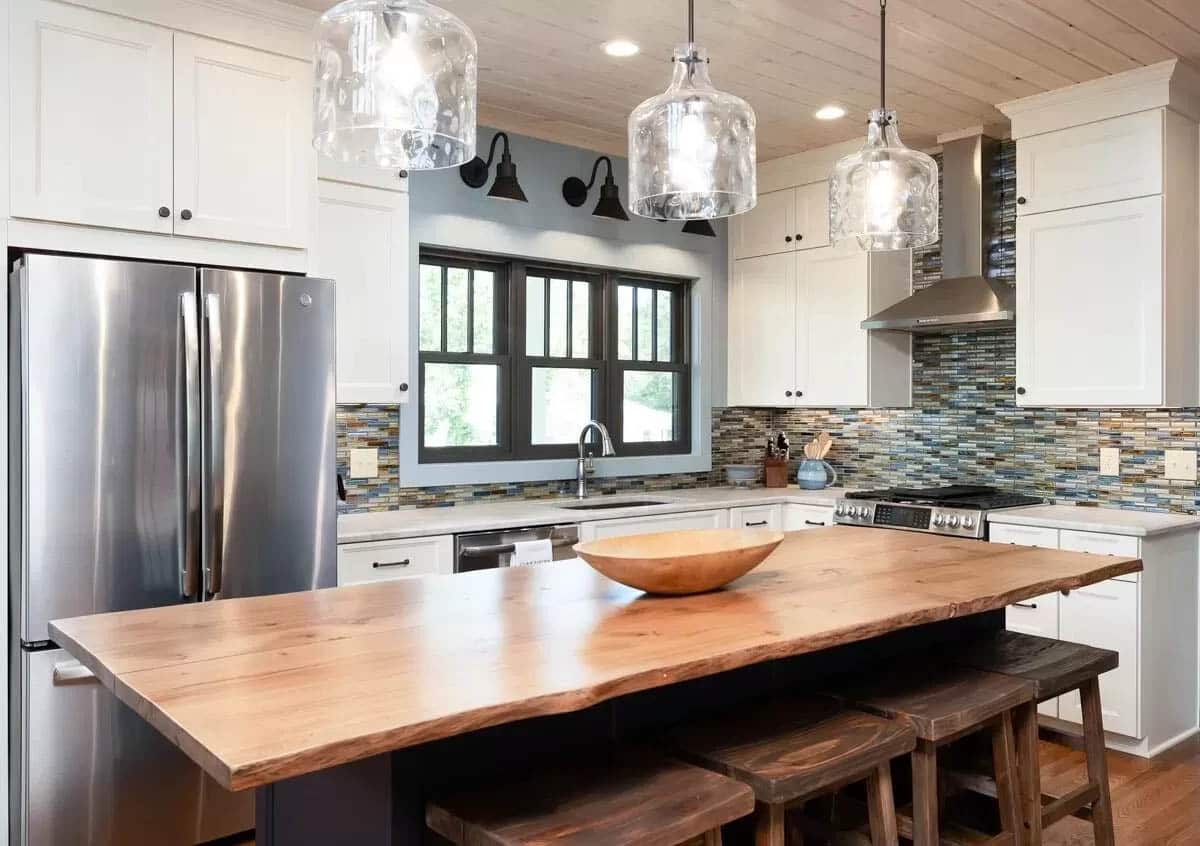 L shaped kitchen with live edge wood island countertop and white cabinetry 