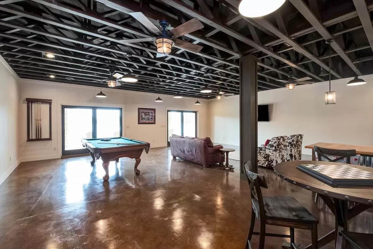 Lower level game room with stained concrete floors 