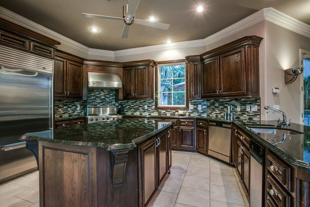 Mediterranean style kitchen with large island and mosaic backsplash