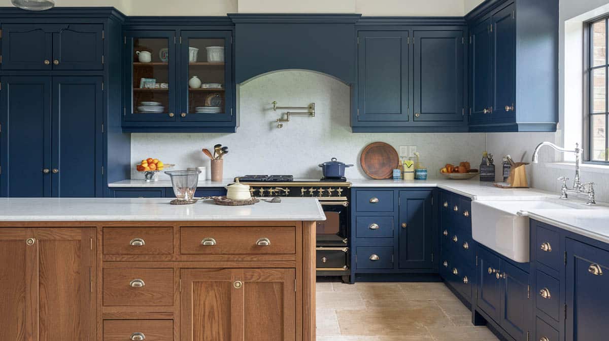 Traditional kitchen with wood grain island, navy toned cabinets and vintage oven