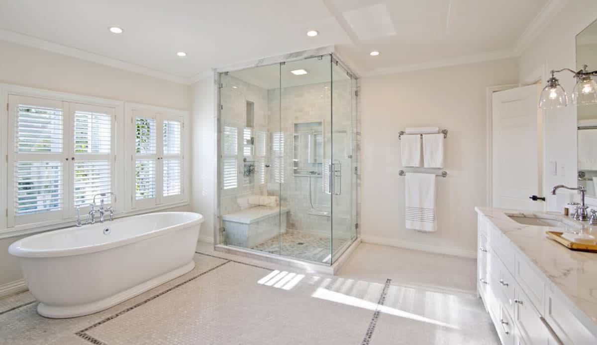 Tub, windows with blinds and white granite countertop
