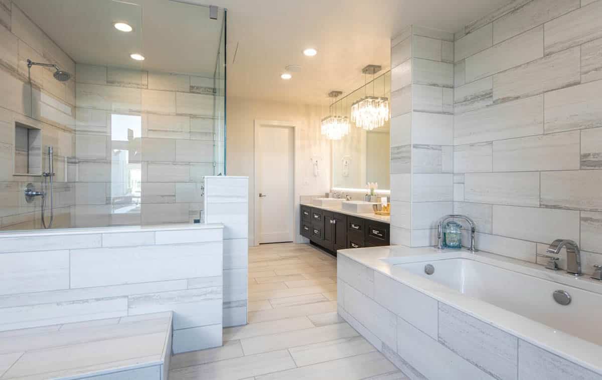 Bathroom with half glass wall and chandeliers