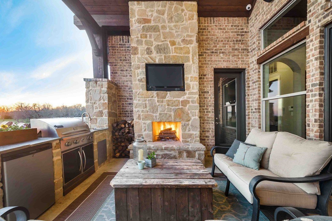 Covered patio with outdoor kitchen and stone fireplace