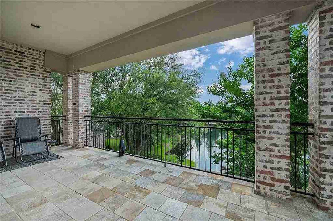 Covered brick terrace overlooking yard