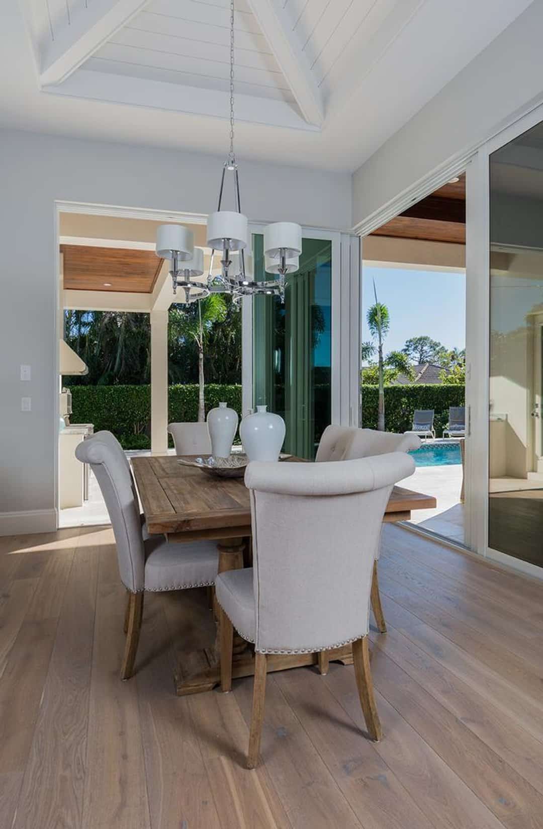 Dining space with wood plank floors and sliding doors to pool patio