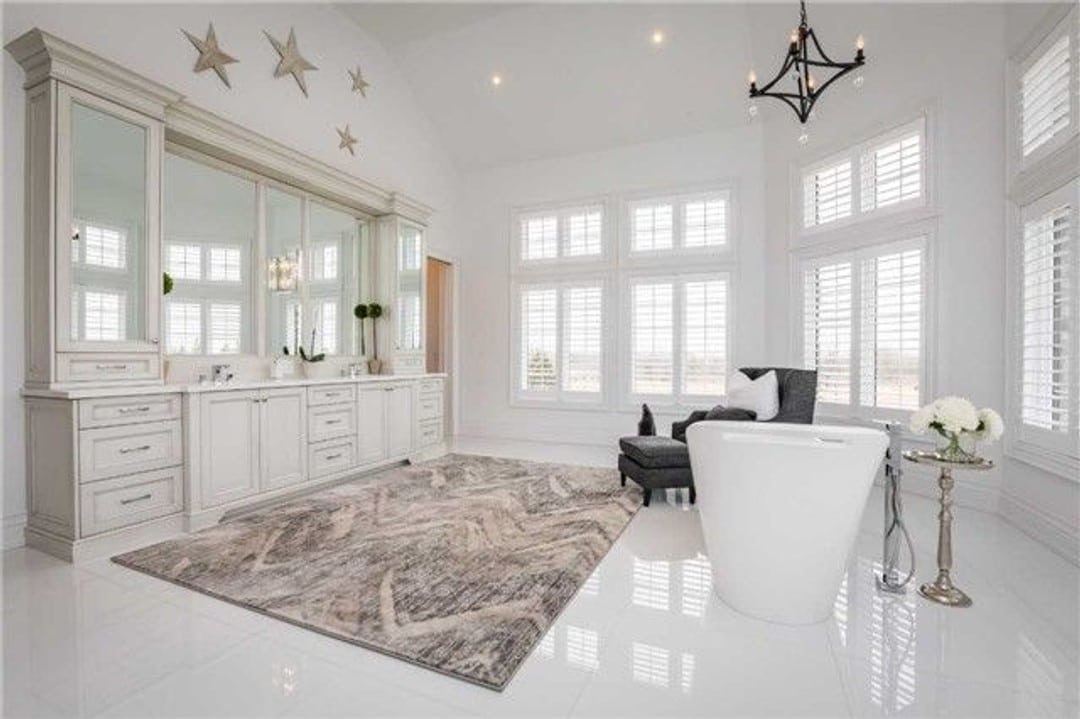 Expansive bathroom with spa-like feel, double vanity and wraparound windows