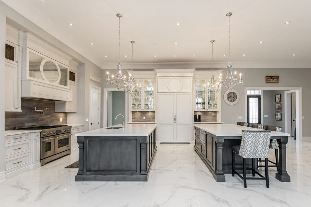 Expansive luxury kitchen with white cabinets and two islands