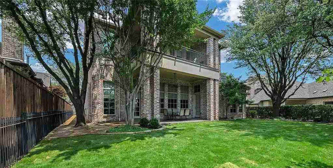 Brick home backyard with lawn area and covered patio and terrace