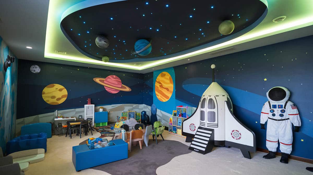 Space exploration themed playroom with planet mural and stars on ceiling