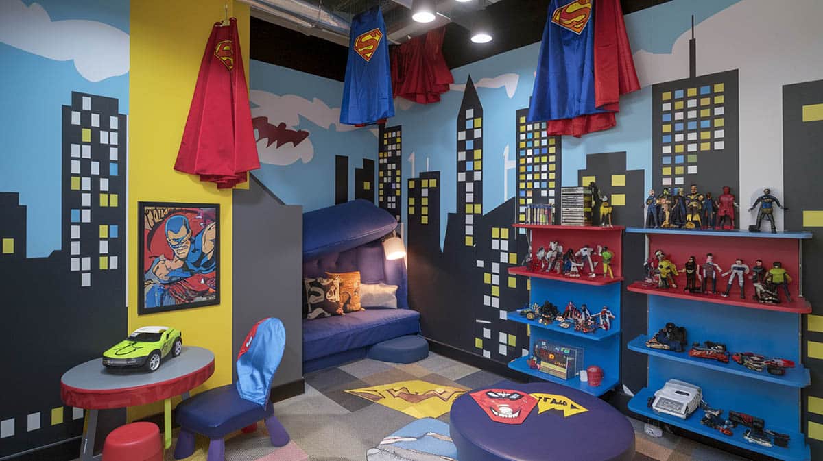 Superhero headquarters playroom with bold colors posters cityscape mural