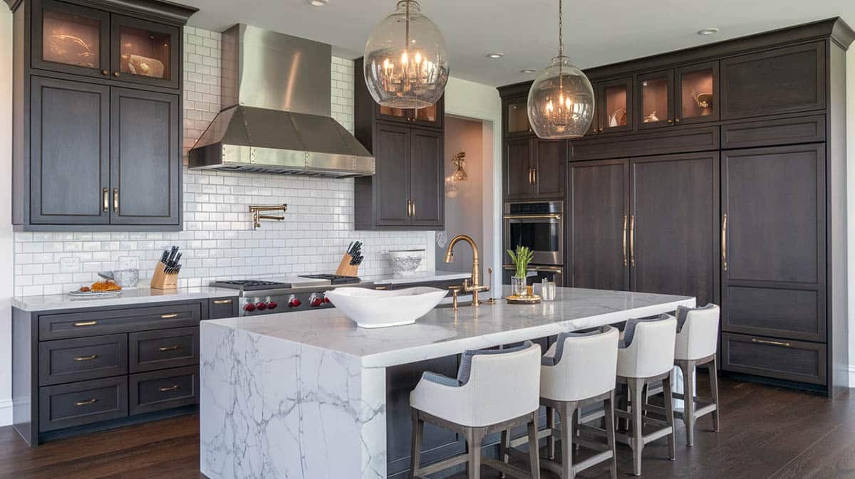 Transitional kitchen with white subway tile backsplash paired with rich chocolate cabinets and waterfall stone island