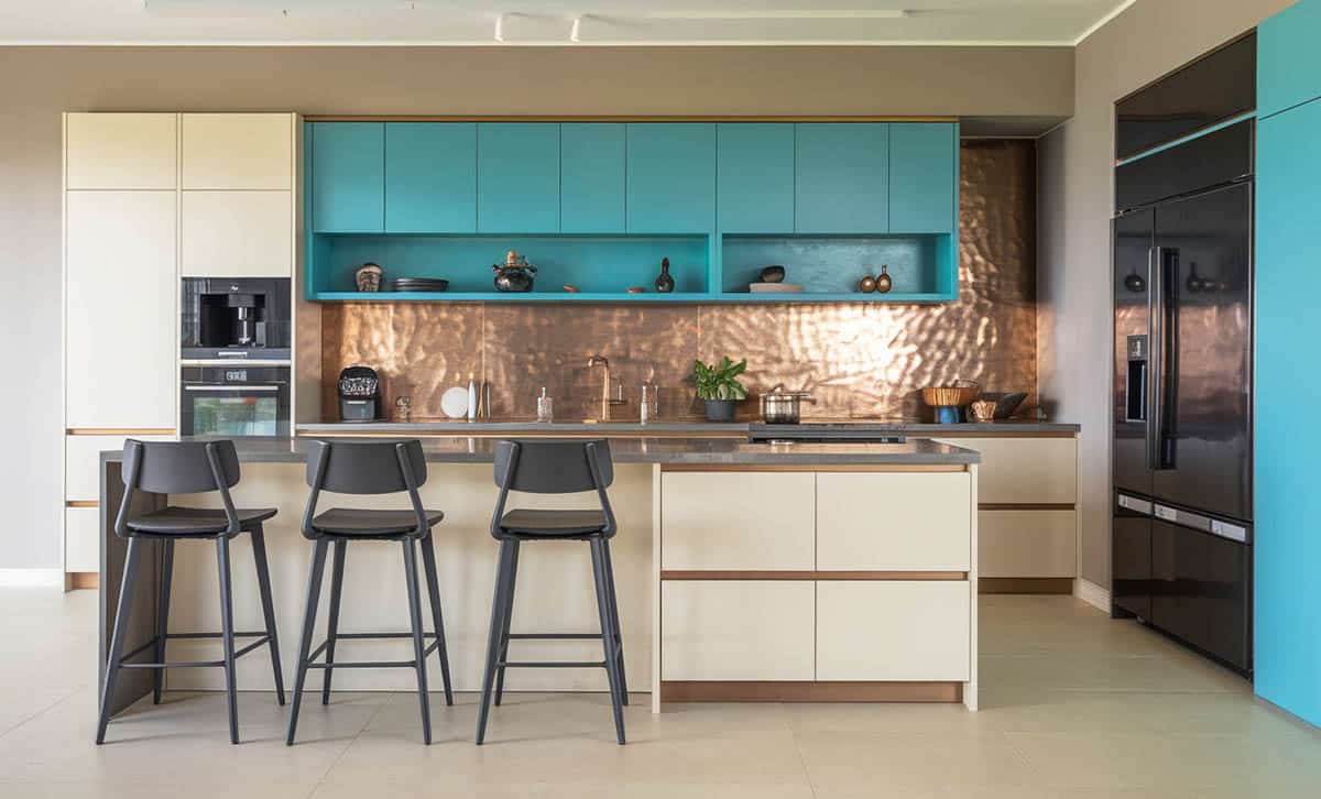 Kitchen showcasing off-white paired with turquoise hued cabinets with hammered copper backsplash