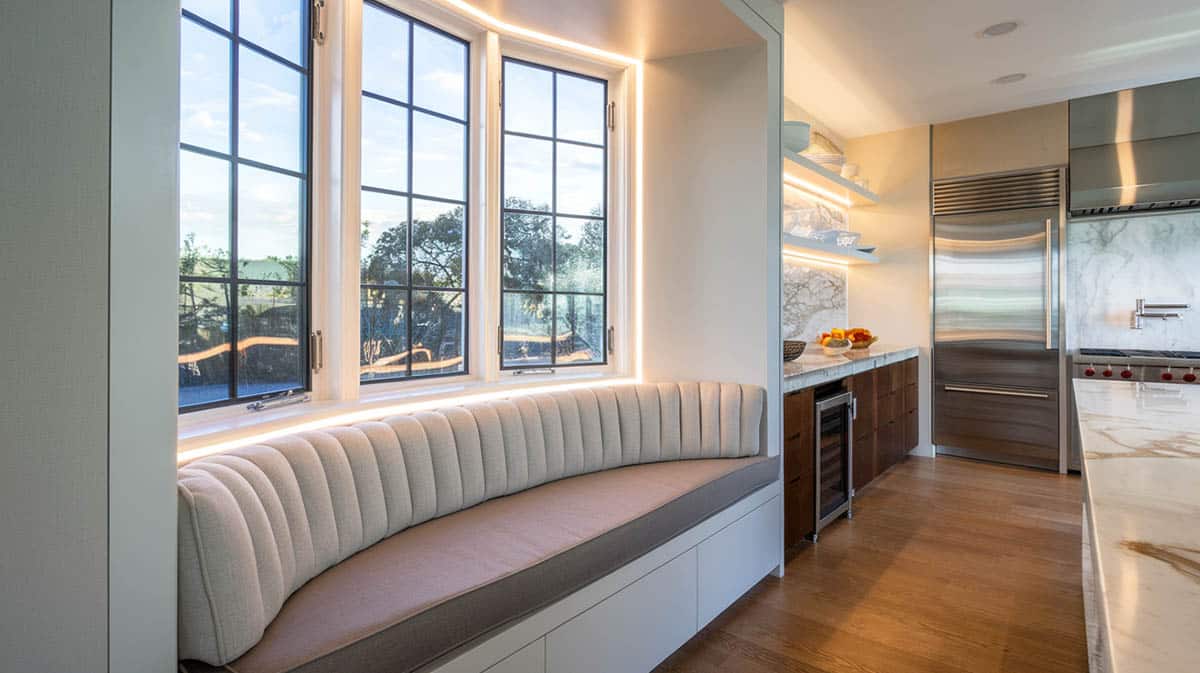 High end modern design kitchen with illuminated window nook and channel tufted cushions