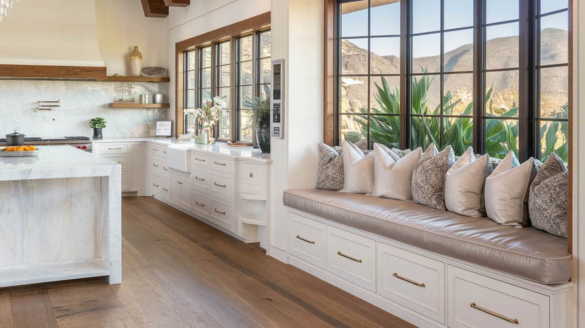 Luxury kitchen with large island and plush bench with mountain view windows