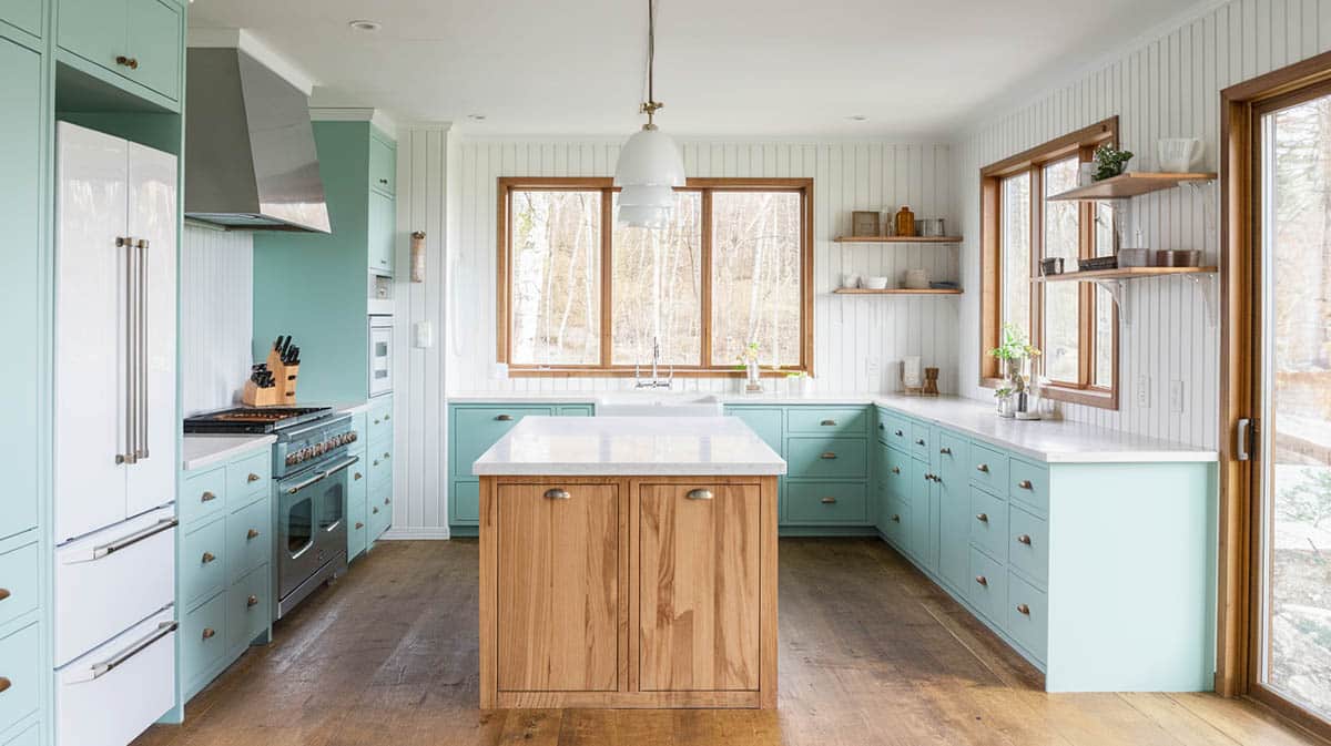 Modern Scandinavian kitchen with light shaded cabinets with white panel walls and wooden finish island