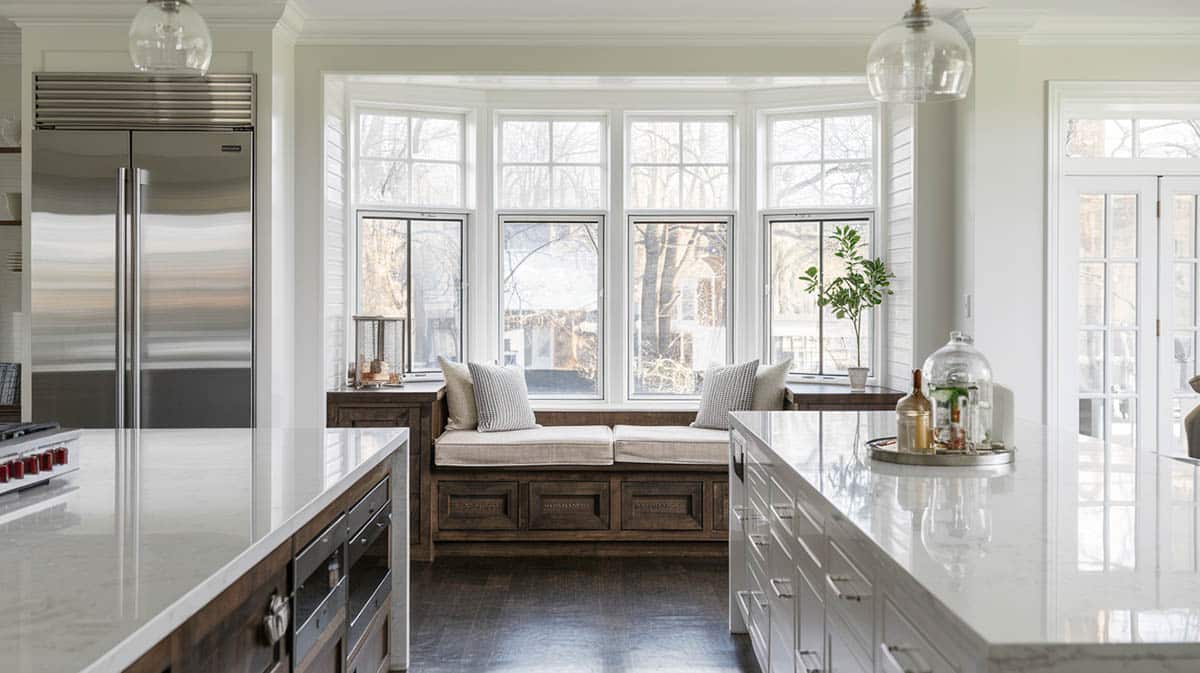 Stylish kitchen with wood seat, cream cushions and quartz island countertops